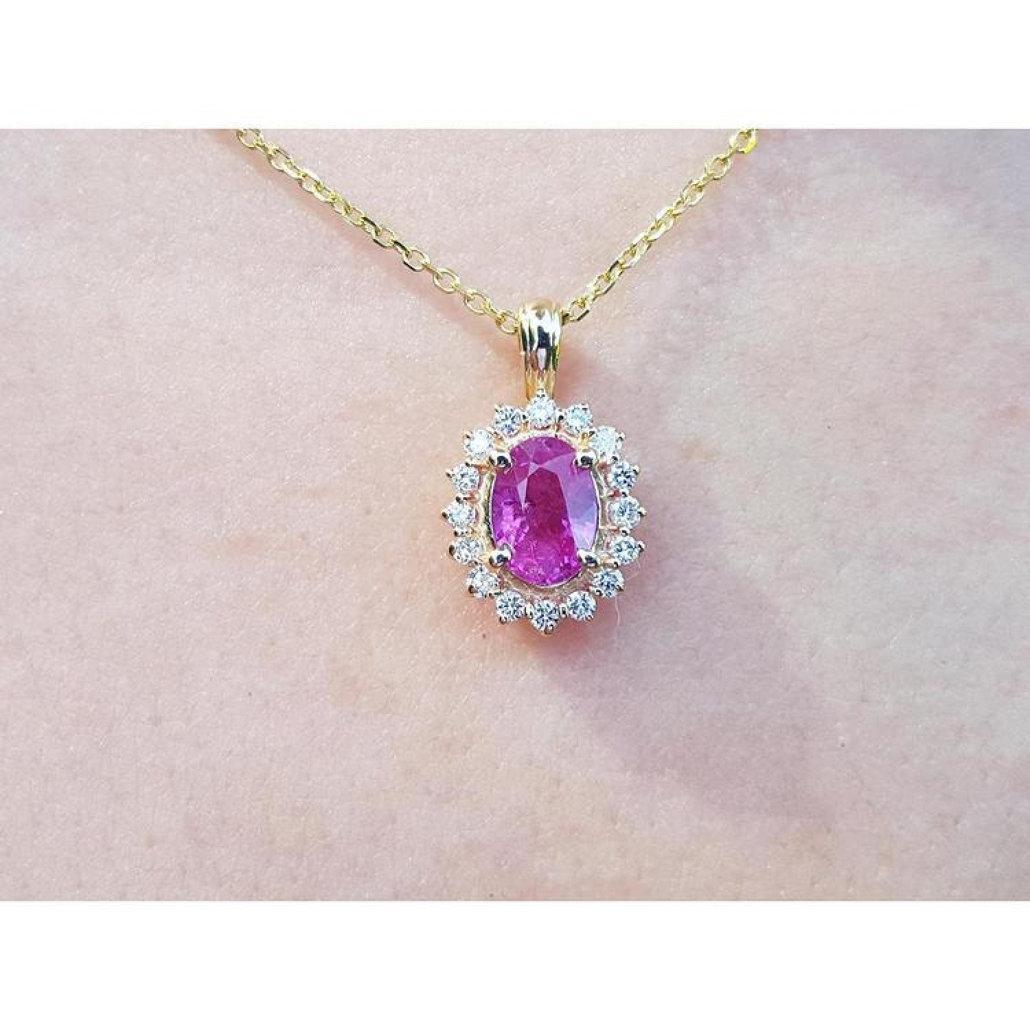 1.25 ct. oval pink sapphire halo diamond pendant on a 14K yellow gold chain.