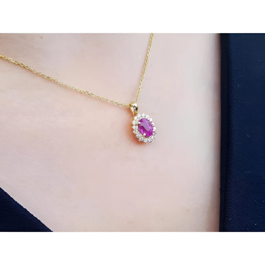 Oval pink sapphire halo diamond pendant necklace in 14K yellow gold.