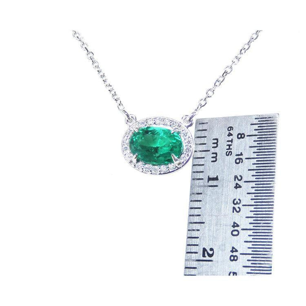1.00 ct oval emerald necklace with diamond halo, 14K white gold chain, shown with ruler.