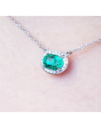Colombian oval cut emerald necklace east west orientation halo natural diamonds prong set crafted in 14k white gold 