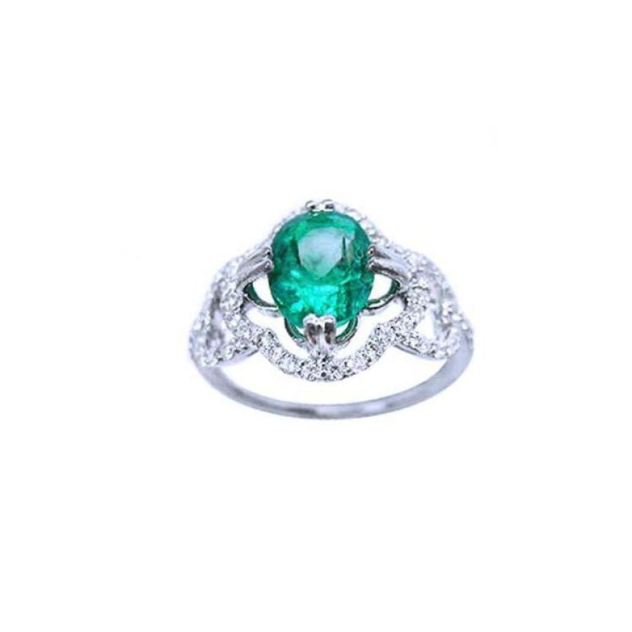 1.55 ct. oval emerald clover ring with diamond halo in 14K white gold.