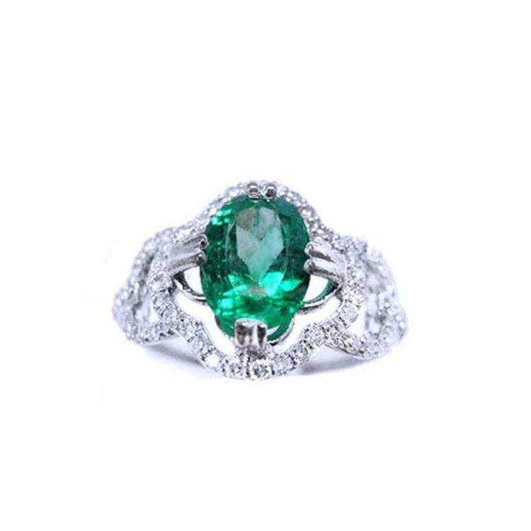 This oval-cut emerald, elegantly set at the heart of a four-leaf clover design framed by a halo of diamonds is in 14K gold.