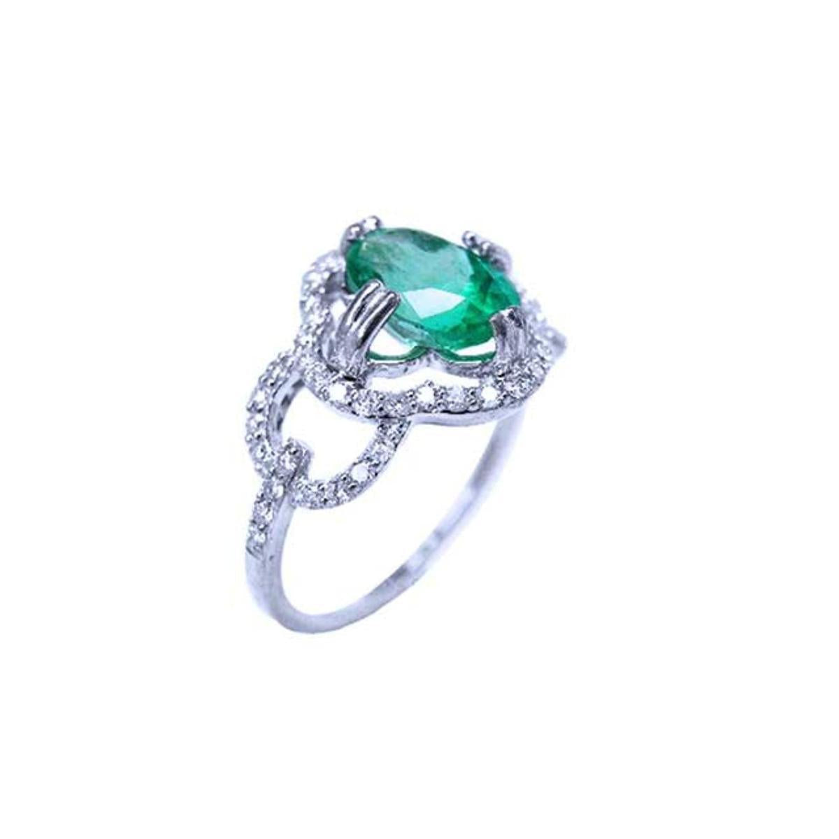 A 14k white gold ring with an oval cut emerald and diamond accents on a white background.