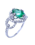 A 14k white gold ring with an oval cut emerald and diamond accents on a white background.