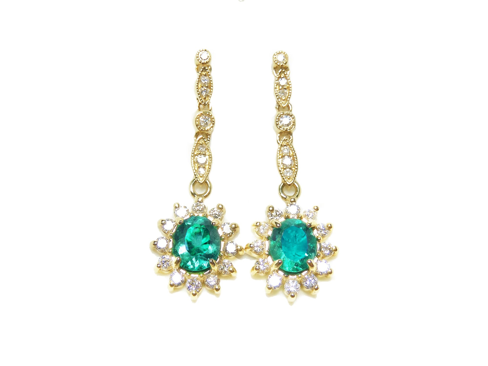 A pair of oval cut emerald halo diamond dangle earrings yellow gold