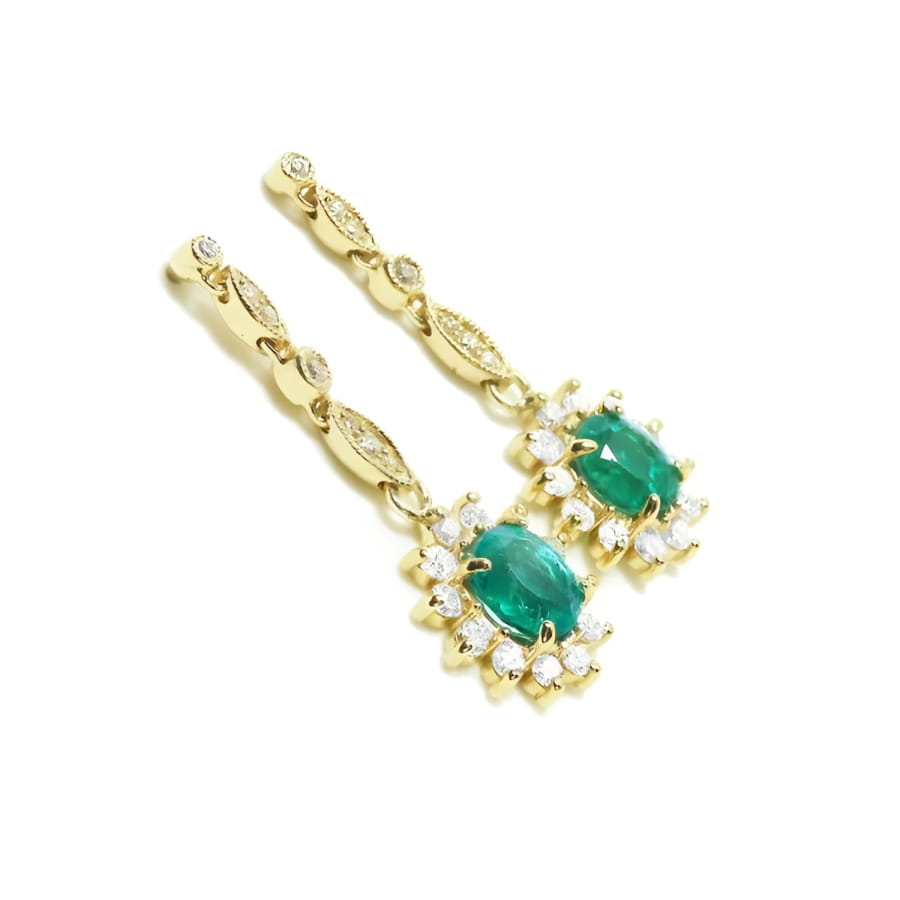 A pair of a 14k yellow gold with natural colombian emerald earrings with a halo diamond.
