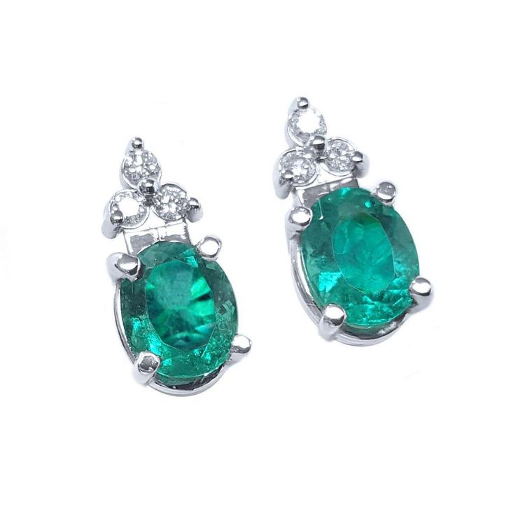 Pair of natural oval emerald earrings with diamond accents in 14k white gold, May birthstone.