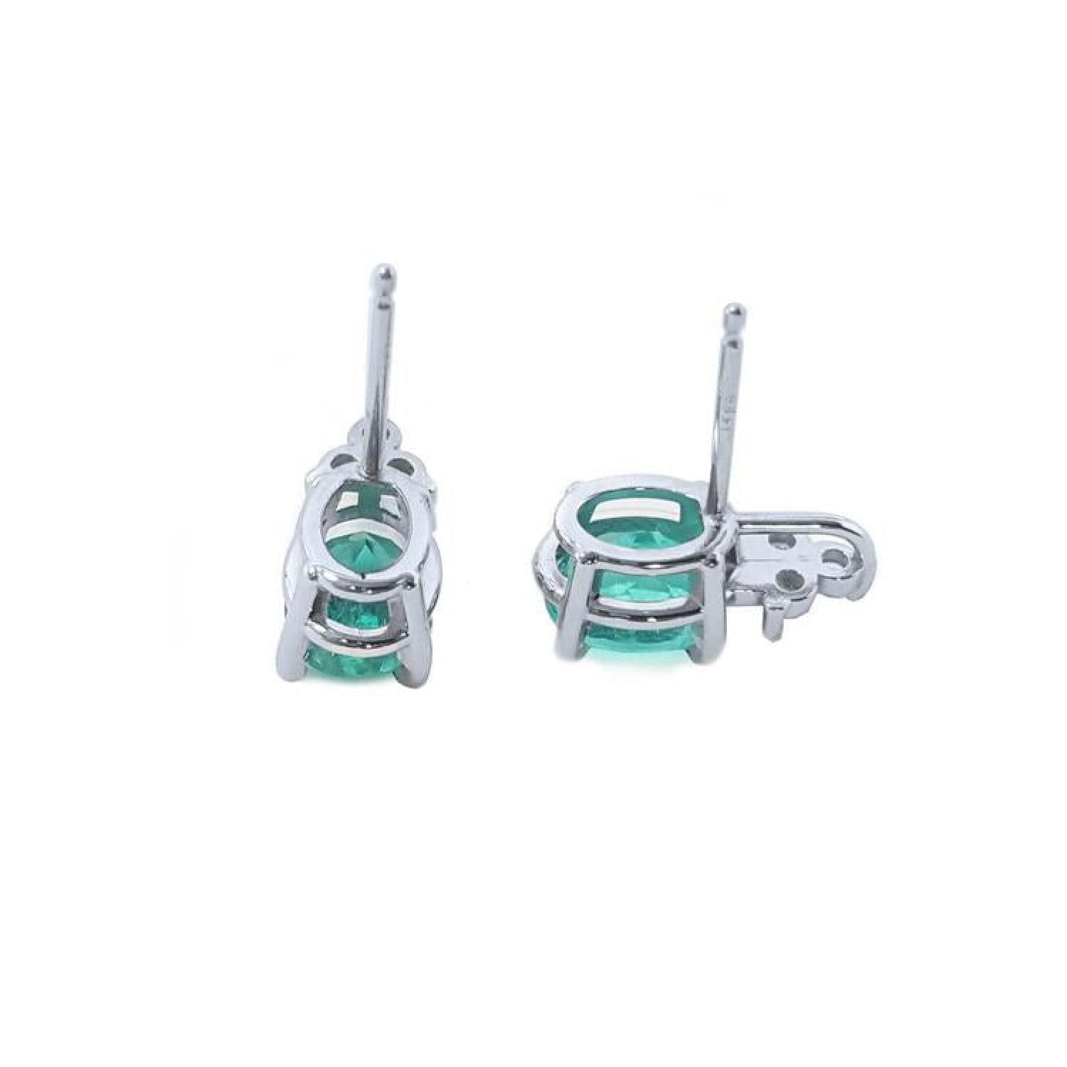 Oval cut natural emerald earrings in 14K white gold with diamond accents.