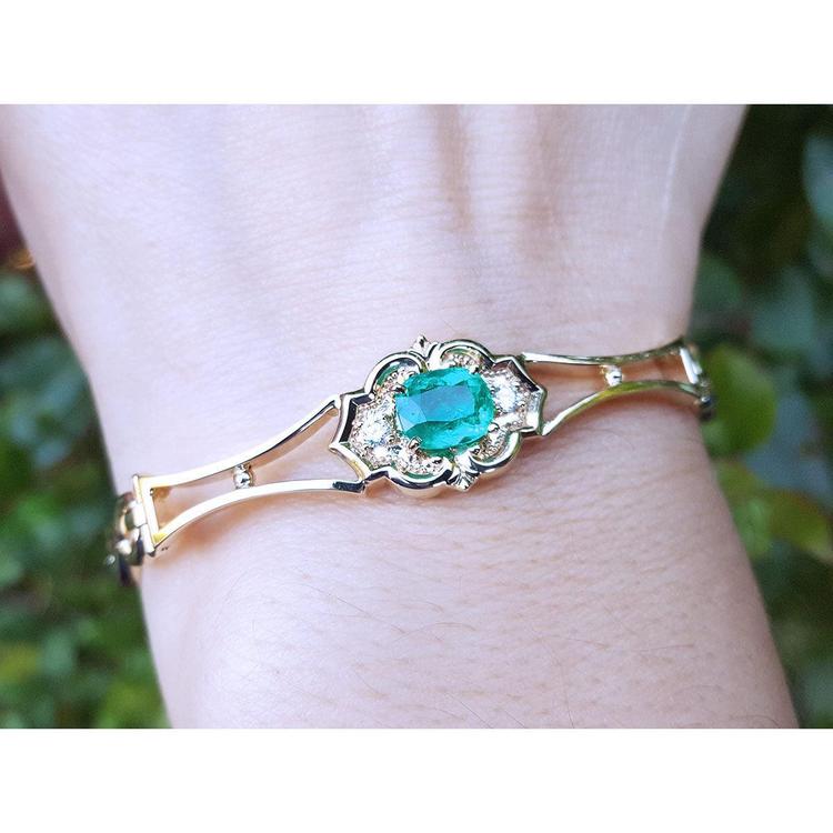 14k gold bracelet with a natural colombian emerald oval cut and accent diamonds.