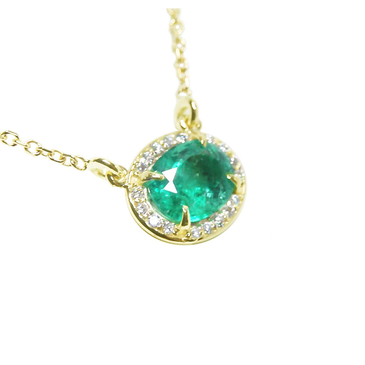 Oval Muzo emerald necklace with diamond halo on 14K yellow gold chain.