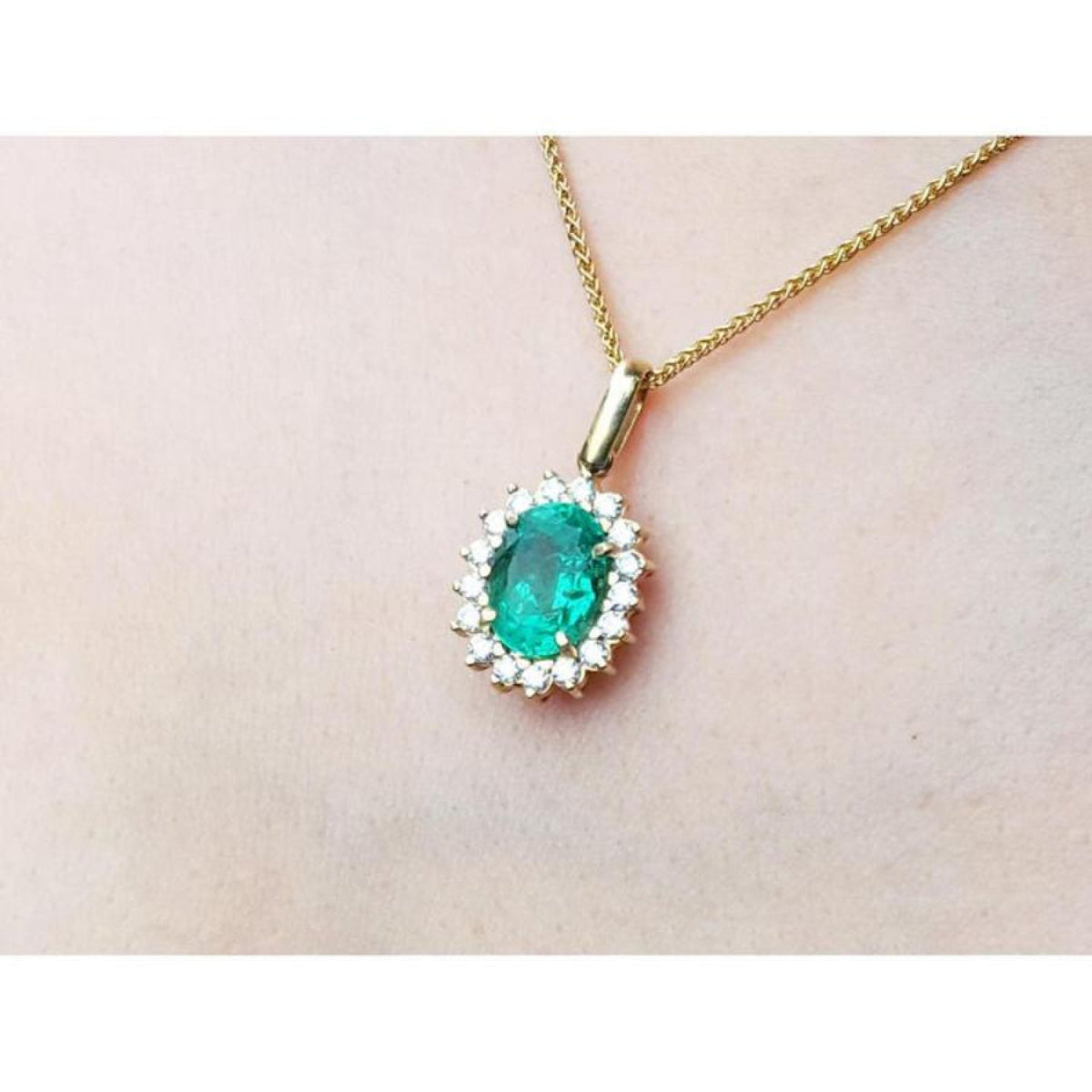 18k gold necklace with an oval cut natural emerald necklace pendant in a halo diamond.
