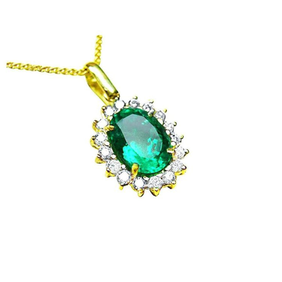 A 18k yellow gold pendant with an oval cut natural colombian emerald with a halo diamond, topside view.