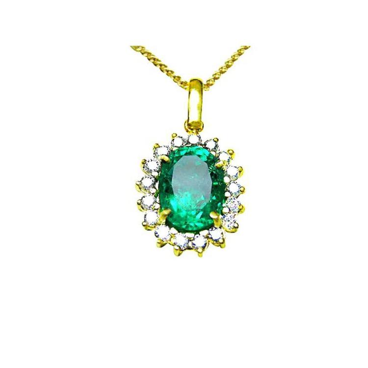 A natural oval cut colombian emerald encircled into a halo diamond pendant necklace in 18k yellow gold.