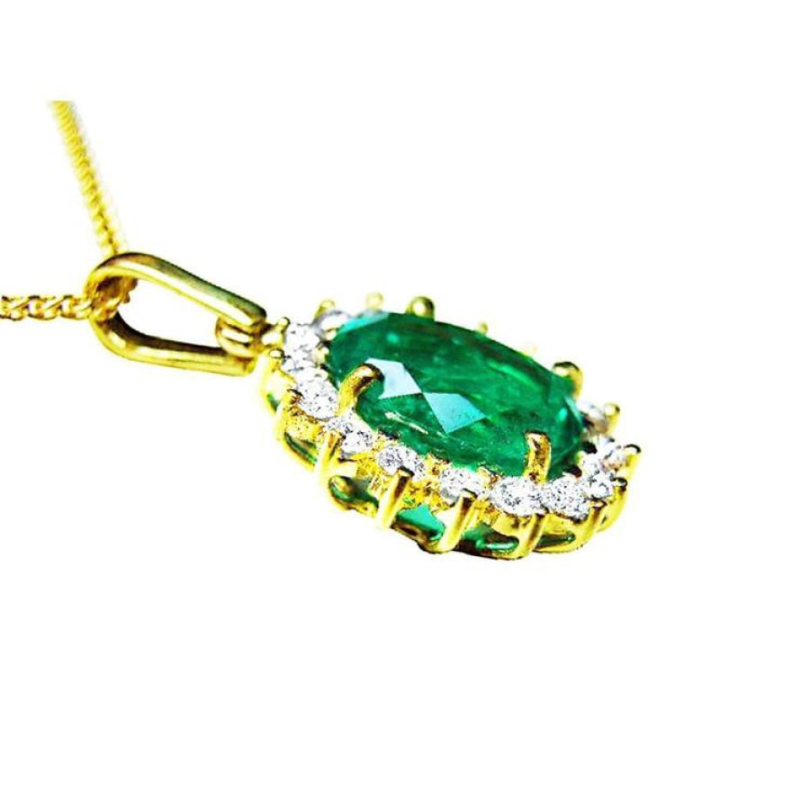 Oval natural emerald pendant with halo diamonds in 18K yellow gold.