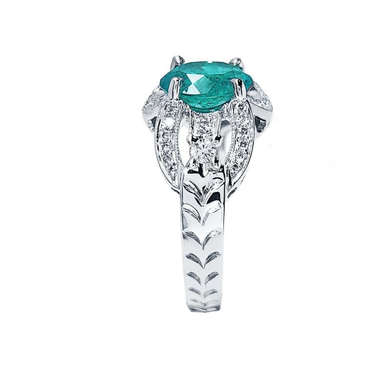 Natural oval emerald ring in 18K white gold with decorative bridal-style band and diamond accents.
