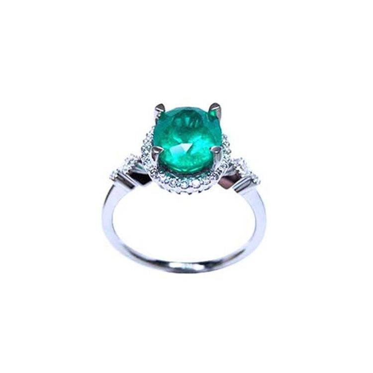 14K white gold halo ring with a deep green oval-cut emerald and sparkling diamond accents.