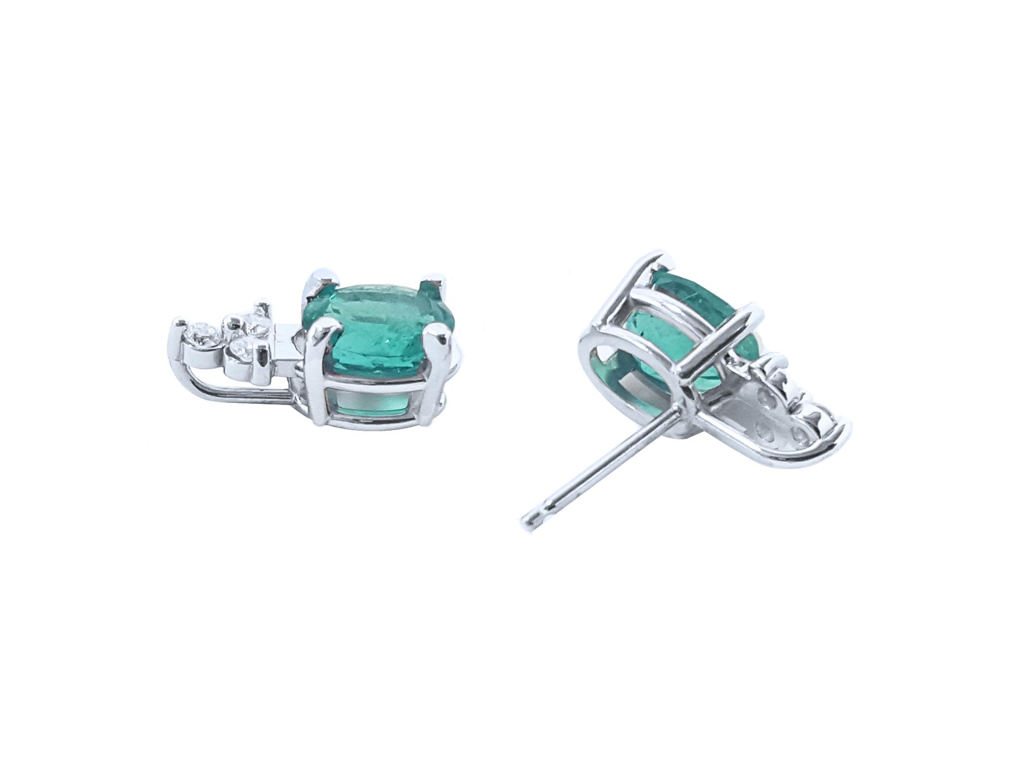 A pair of emerald earrings ocal cut white gold in upside down positions underside view