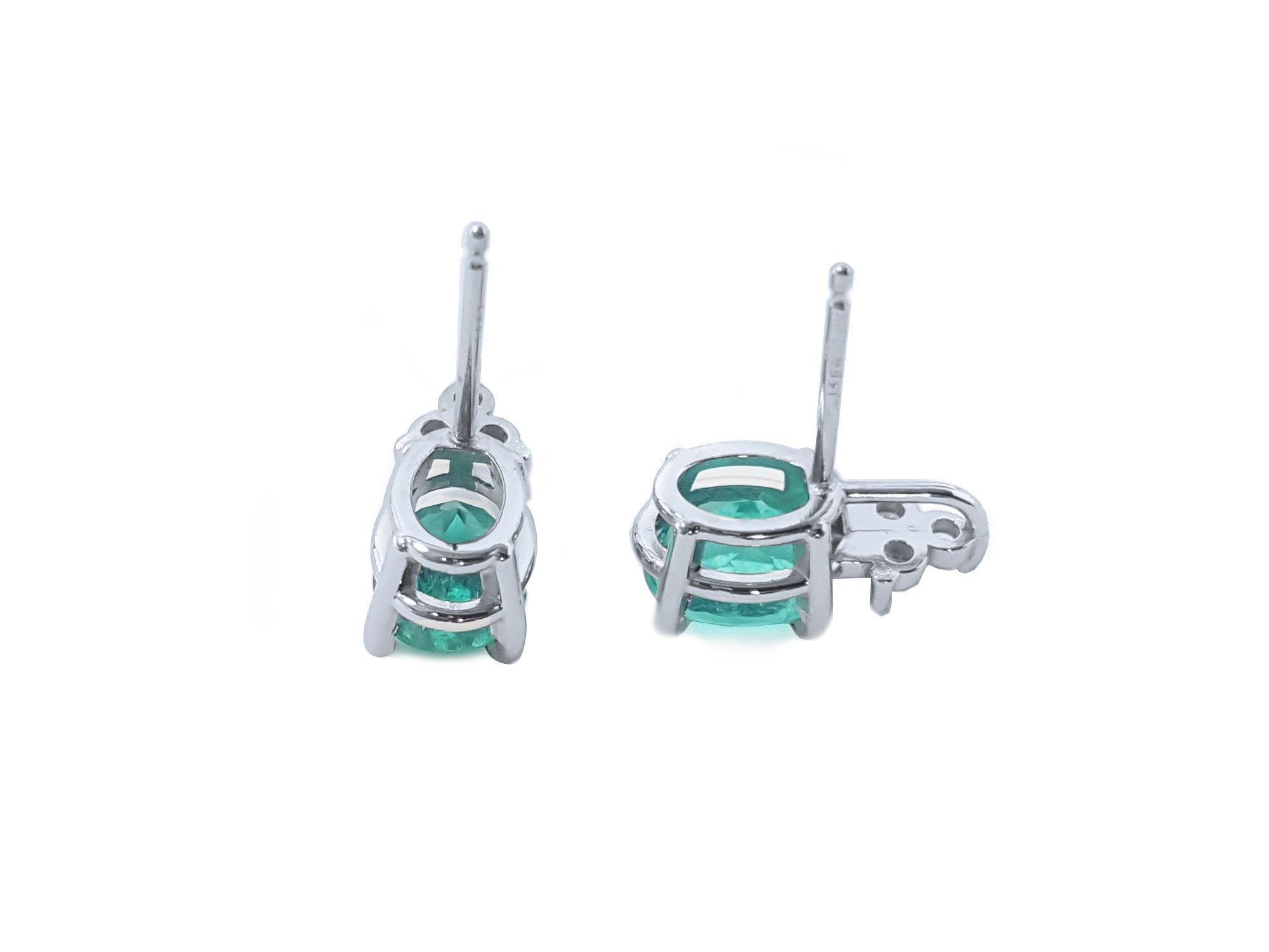 Two oval cut emerald earrings in white gold upside down position to see underside details