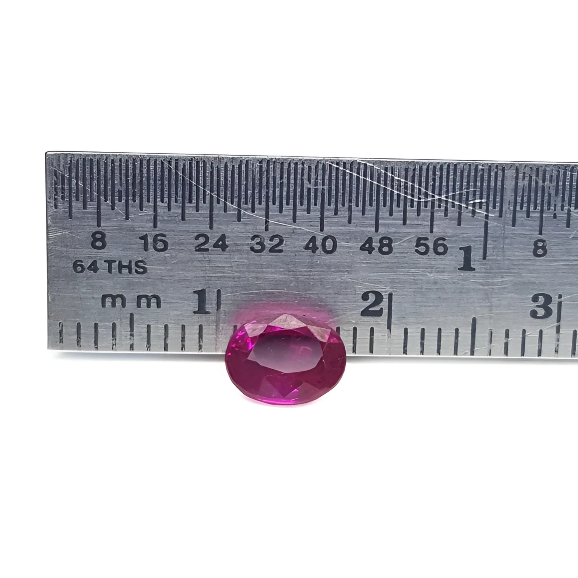 1.31 ct. oval-cut natural Burma ruby gemstone with vivid red hue, measured by a ruler.