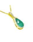 18K yellow gold teardrop emerald pendant with diamond halo on a delicate chain.