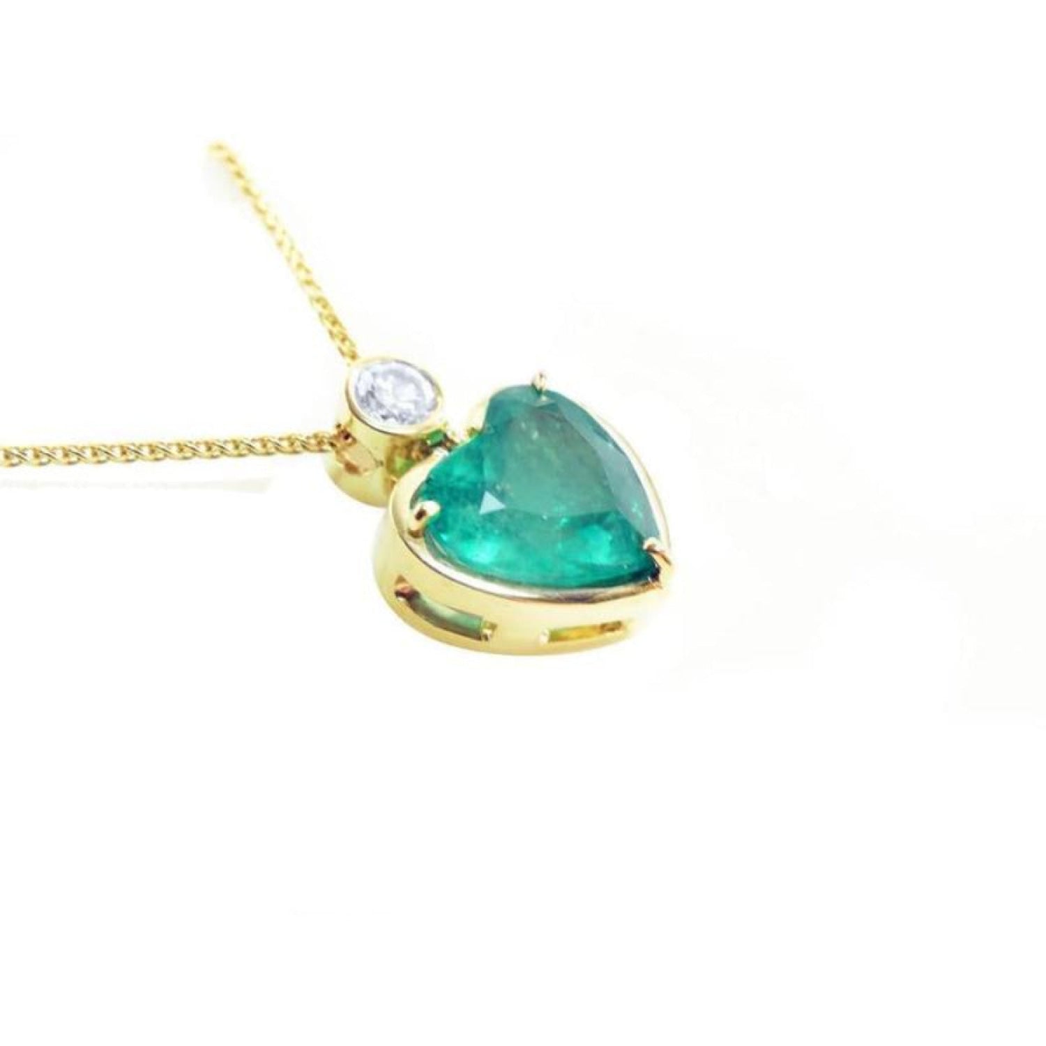 Heart-shaped emerald pendant in 18K yellow gold with a slider bail and bezel-set diamond.
