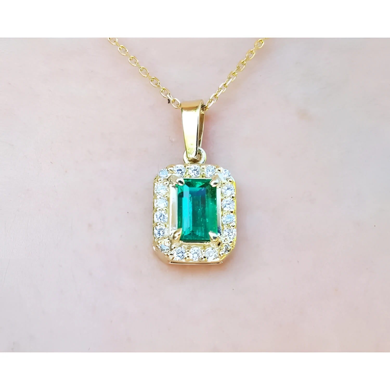 0.75 ct. GIA certified F1 Colombian emerald pendant with diamond halo in 18k yellow gold.