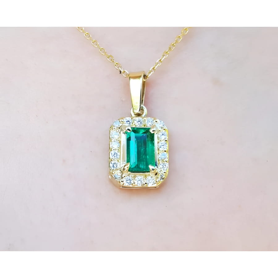 0.75 ct. GIA certified F1 Colombian emerald pendant with diamond halo in 18k yellow gold.