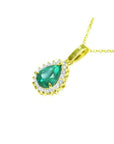 Pear-shaped Colombian emerald pendant with halo diamonds on a 14K yellow gold chain.