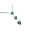 Three hearts emerald journey pendant necklace in 14k white gold.