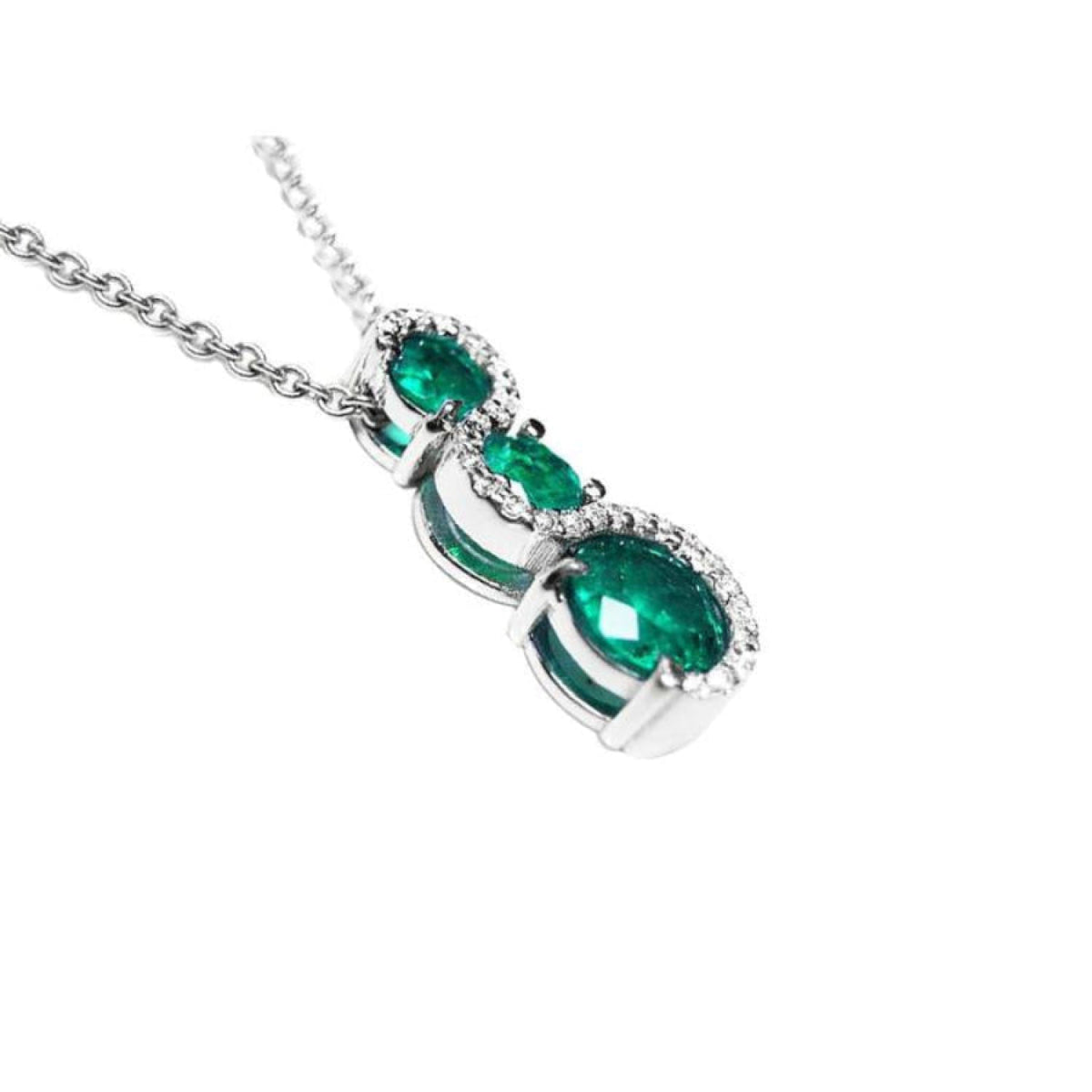 14K white gold emerald journey pendant with three round-cut Colombian emeralds and diamond accents.