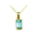 This solitaire colombian emerald pendant displays the topside with a 14k yellow gold frame on a chain.