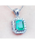 A natural colombian emerald gemstone pendant with a 14k white gold and diamonds frame.
