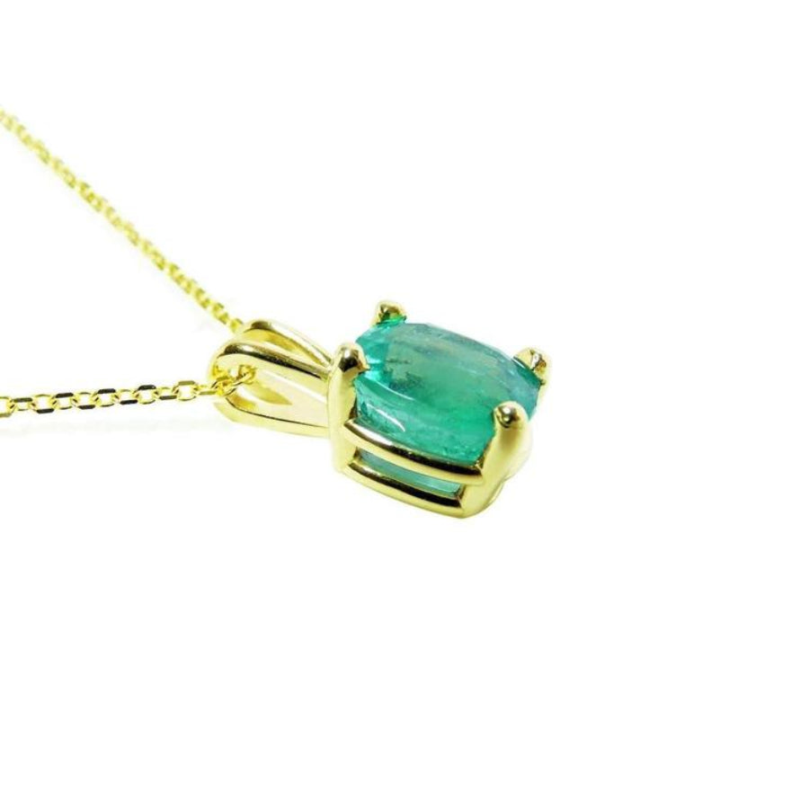 Cushion cut natural emerald solitaire pendant in 14K yellow gold with four-prong setting.