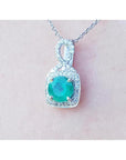 A 18k white gold pendant with a natural round cut colombian emerald from the Muzo mines.