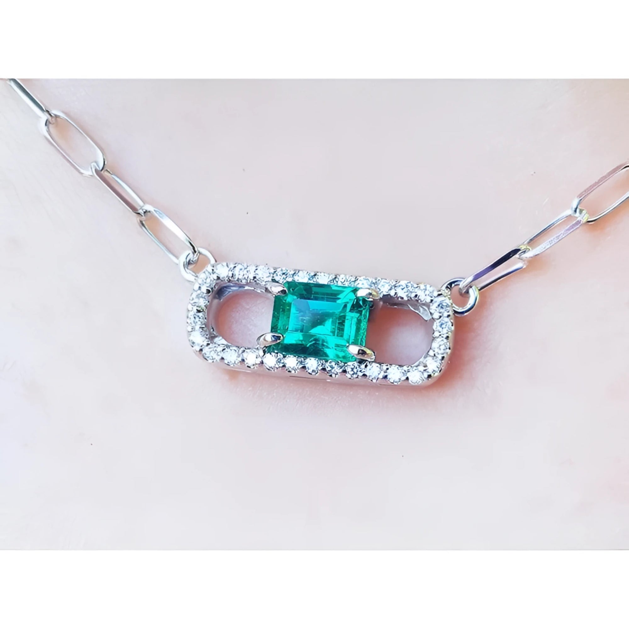 18K white gold paper clip necklace with a vibrant emerald and diamond pendant.