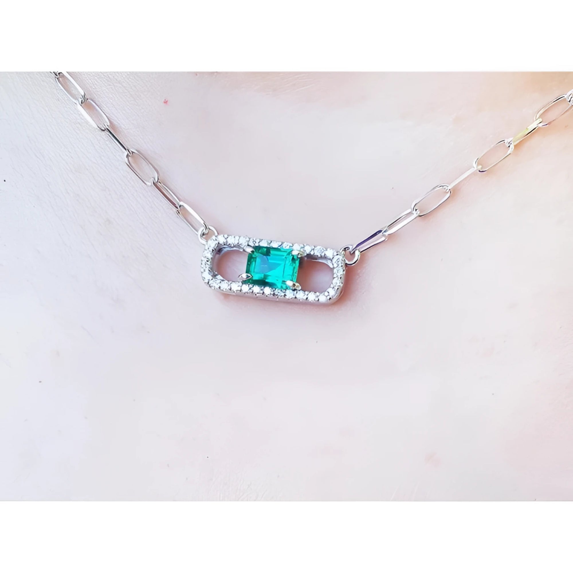 18K white gold paper clip necklace with a vibrant emerald and diamond-studded rectangular pendant.