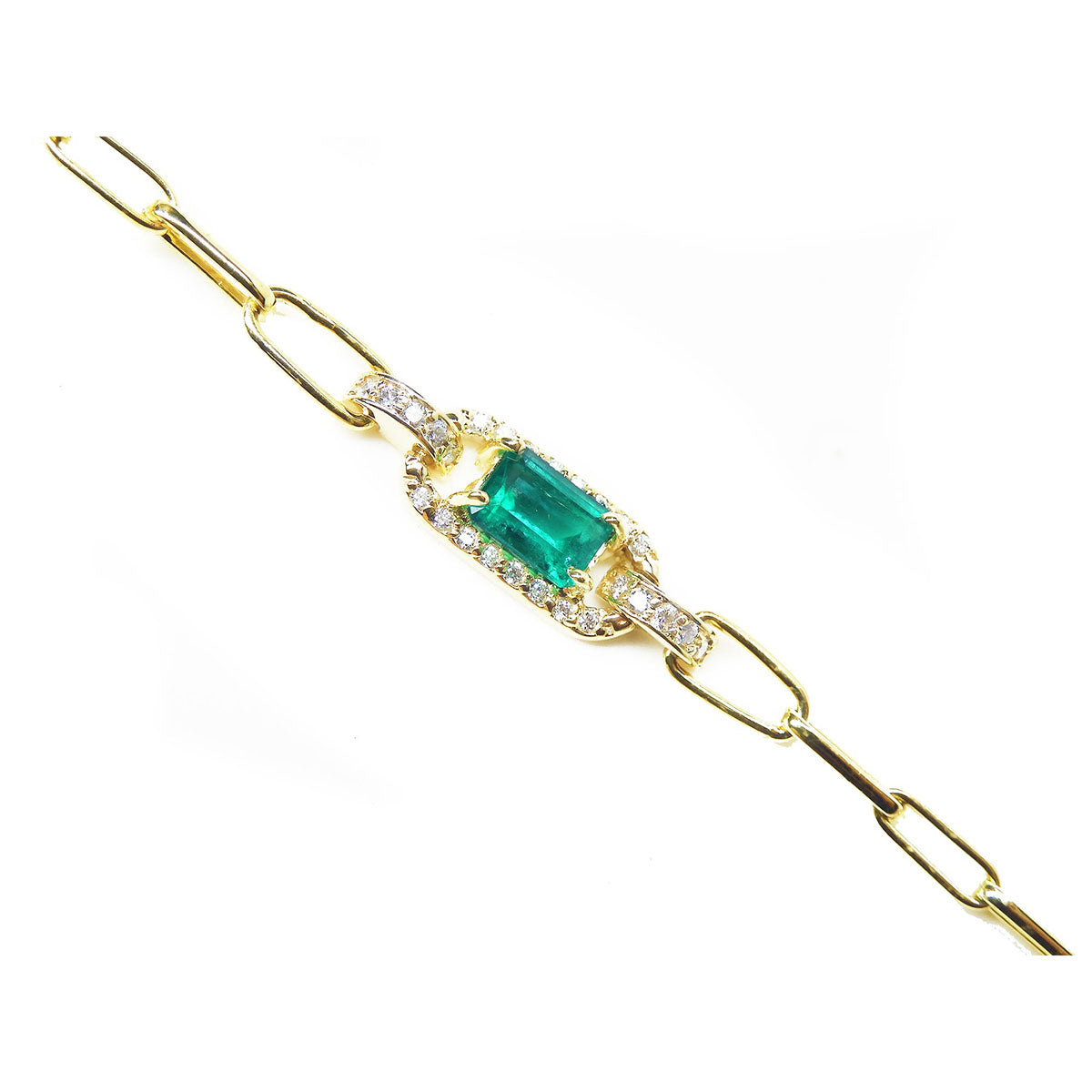 The lateral side view of a gold paperclip bracelet with a Muzo colombian emerald and diamonds.