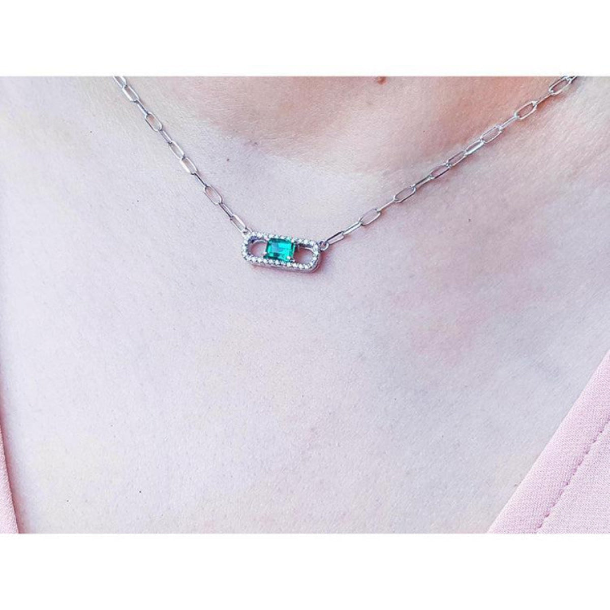 0.68 ct paper clip emerald necklace with diamonds in 18K white gold on a woman's neck.
