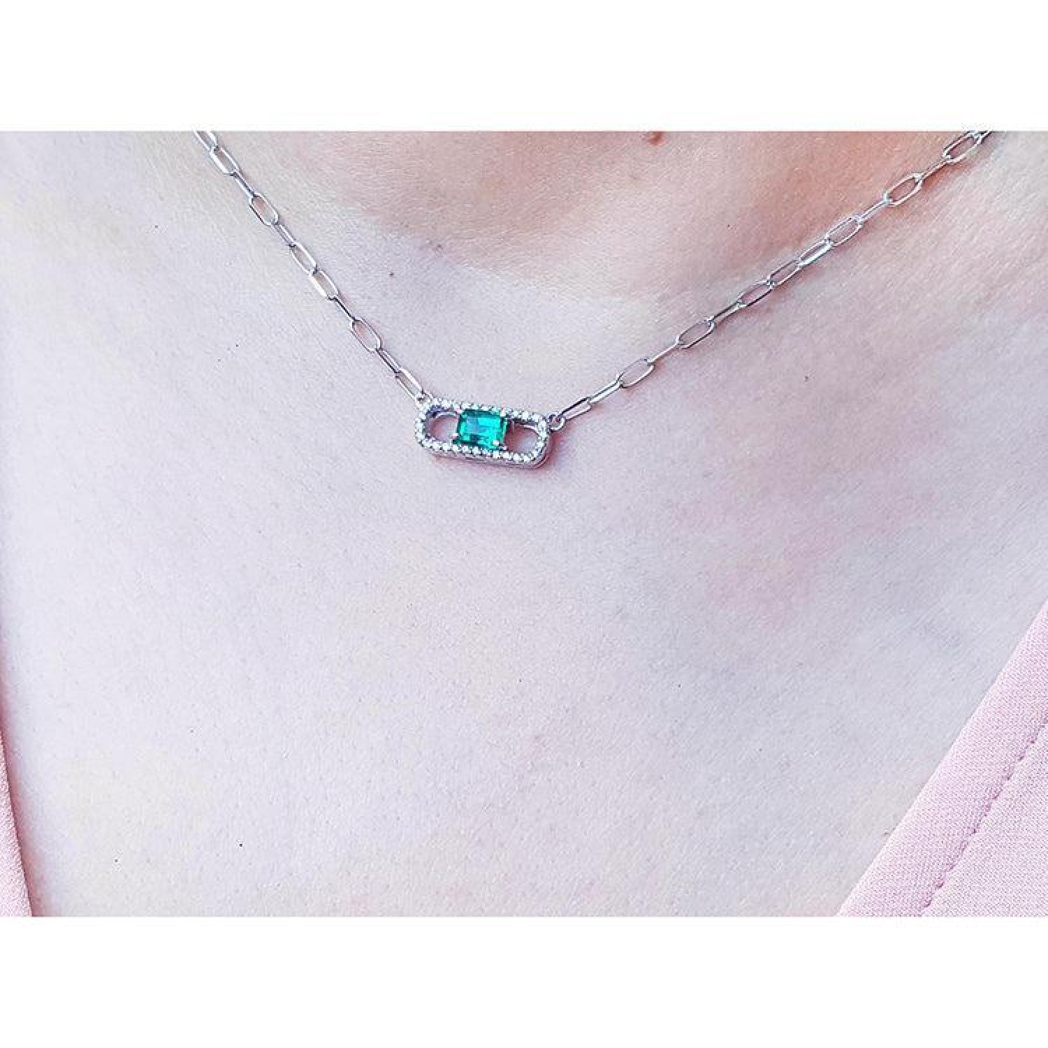 0.68 ct paper clip emerald necklace with diamonds in 18K white gold on a woman's neck.