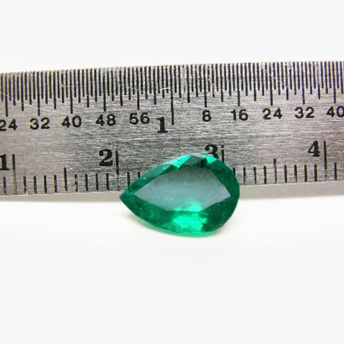 Pear cut natural loose Colombian emerald next to a ruler for measuring size