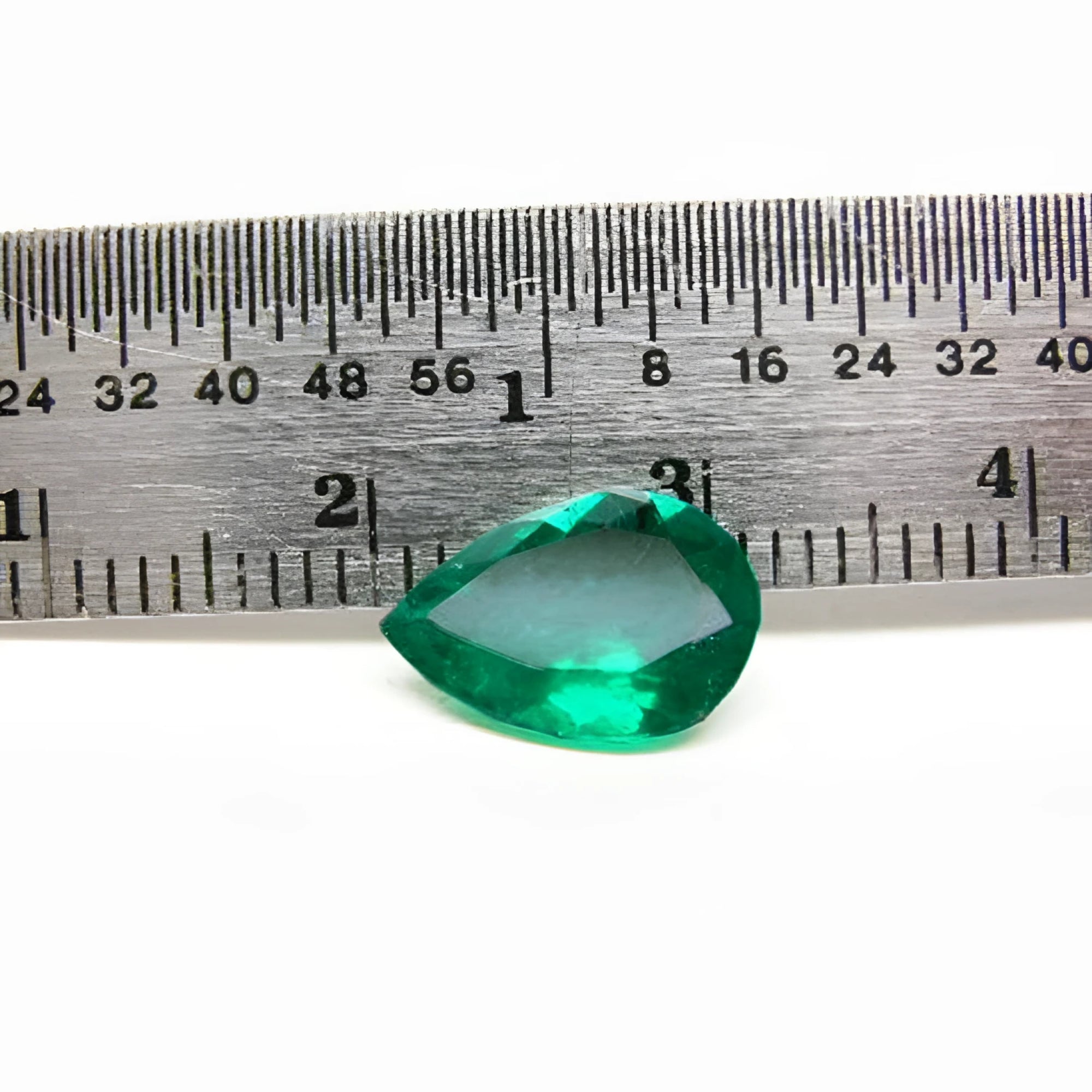1.74-carat pear-cut Colombian emerald, vibrant deep bluish-green, shown next to a ruler.