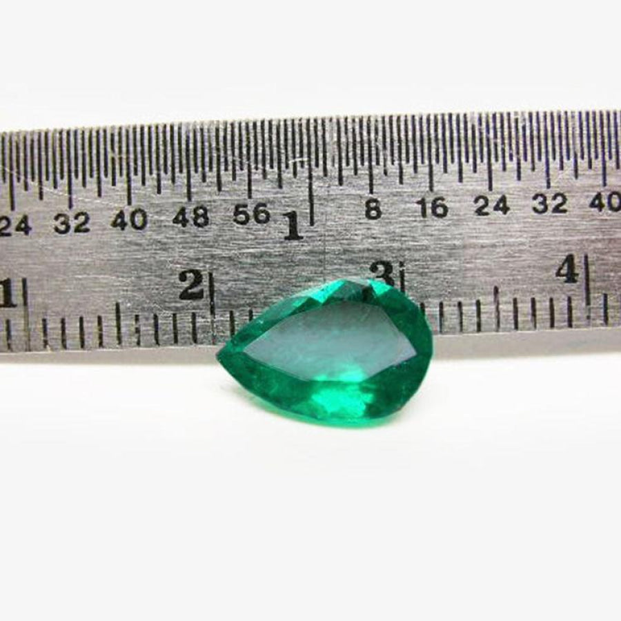 1.74-carat pear-cut Colombian emerald, vibrant deep bluish-green, shown next to a ruler.