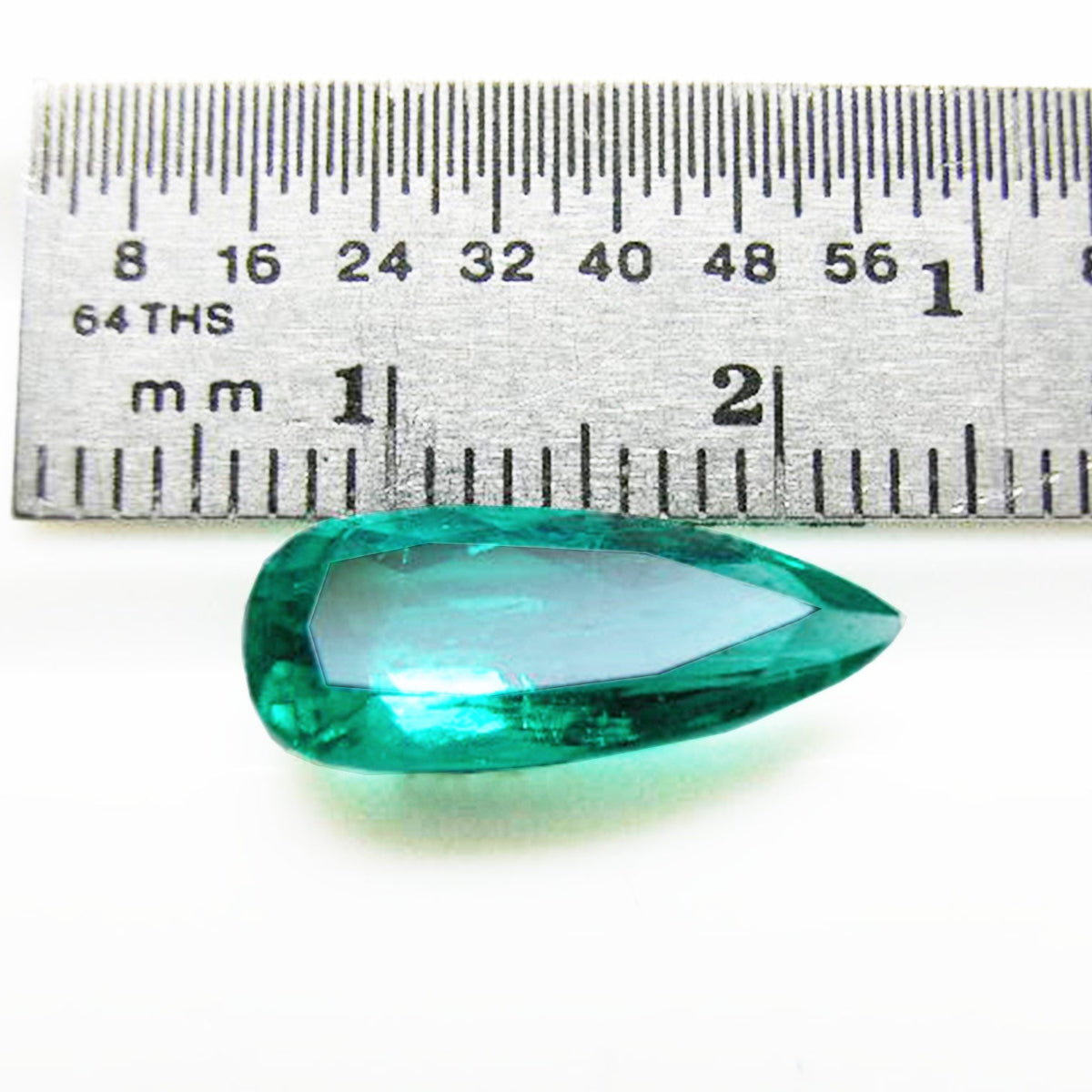 GIA certified Pear shaped loose Colombian emerald, next to a ruler for measuring size