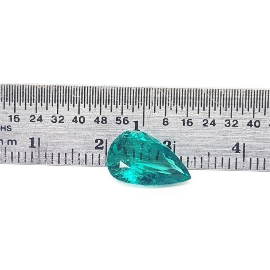 2.65 carat pear cut loose Colombian emerald with vibrant medium deep green hue next to a ruler.