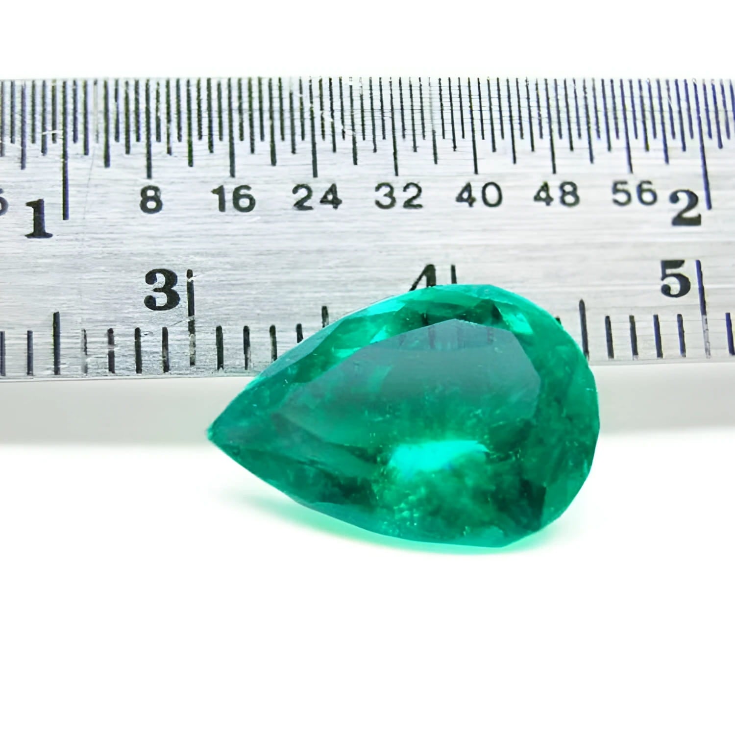 4.17 ct pear-cut natural Colombian emerald with vibrant medium-deep green hue, shown with ruler for scale.