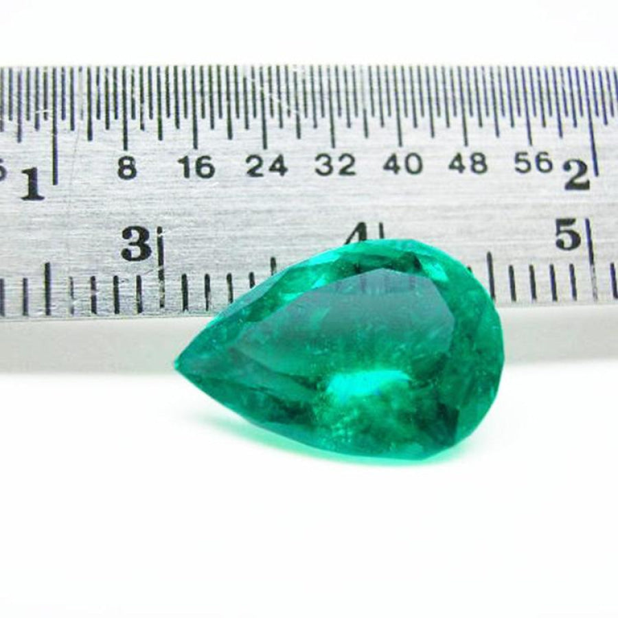 4.17 ct pear-cut natural Colombian emerald with vibrant medium-deep green hue, shown with ruler for scale.