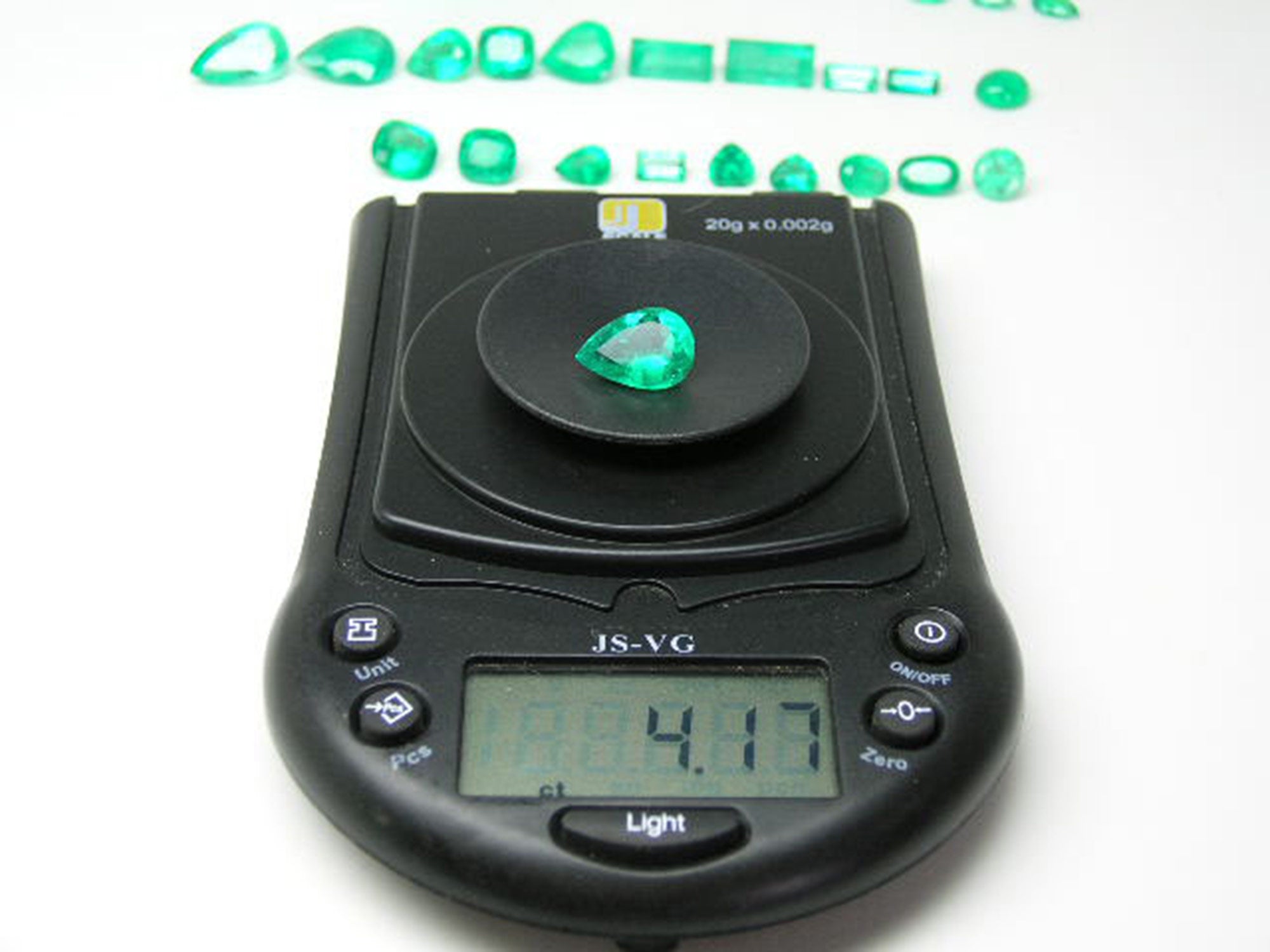 pear cut natural Colombian emerald Muzo mine, on a scale for weight display