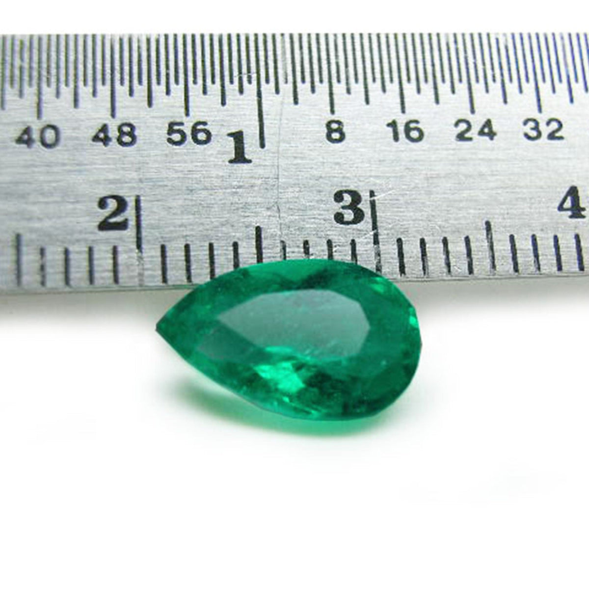 Pear cut natural colombian emerald muzo mine, front side next to a ruler for measuring size