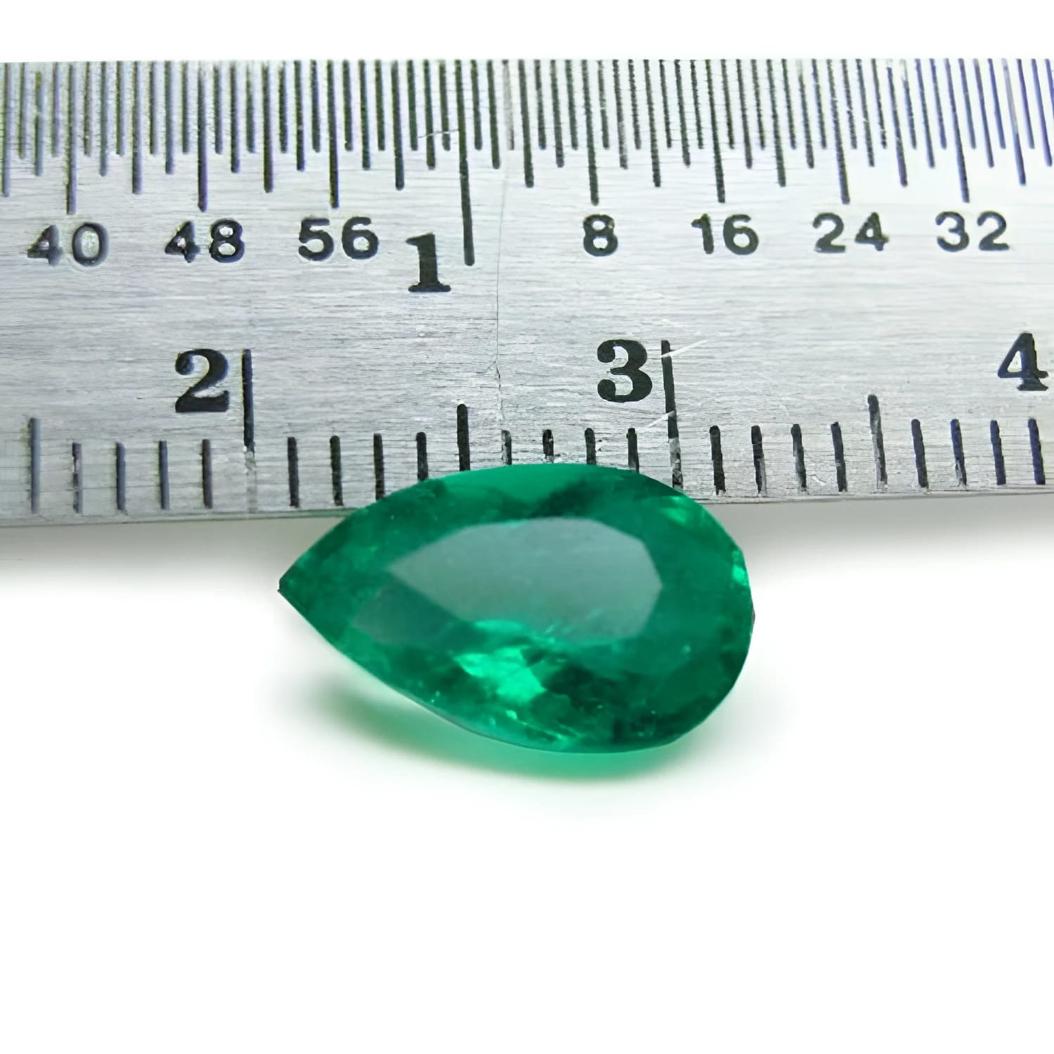 1.84 carat pear-cut natural Muzo Colombian emerald, vibrant bluish-green, shown with a ruler for scale.