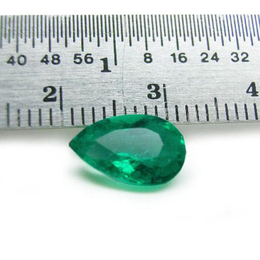 1.84 carat pear-cut natural Muzo Colombian emerald, vibrant bluish-green, shown with a ruler for scale.
